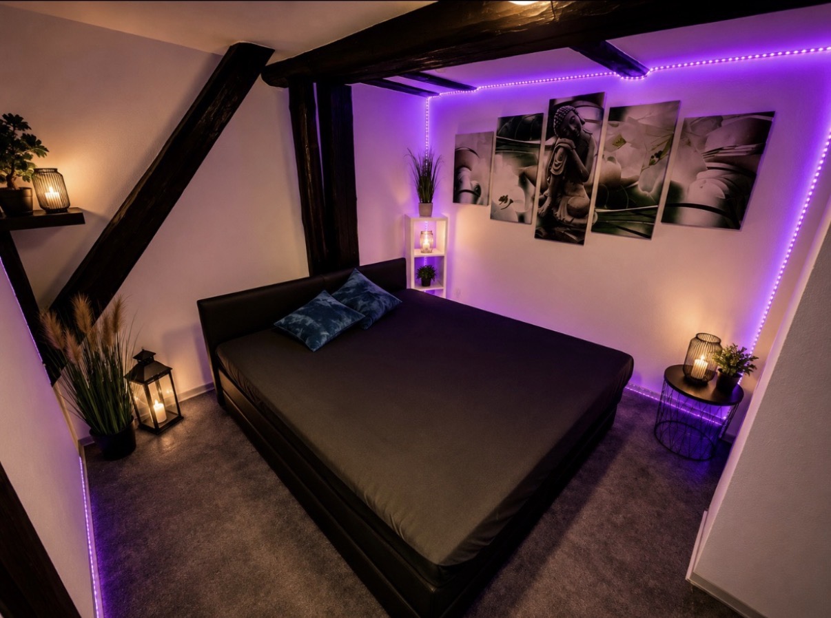 Schlafzimmer mit LED-Ambientelicht und Wandbildern