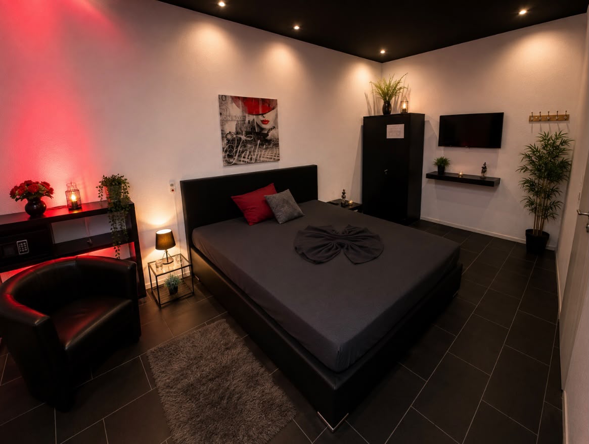 Schlafzimmer mit Sessel und TV